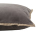Close-up of gray velvet piped cushion with camel-colored trim. A soft, stylish accent pillow for sofas and beds.
