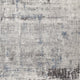Close-up of Zenith area rug showcasing its textured, abstract design with shades of gray, blue, and brown for a modern