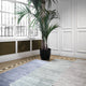 Navy blue Beam rug displayed in a stylish interior with a palm tree, showcasing its texture and design. thumbnail_3